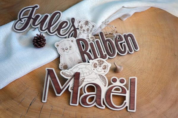Lettres de prénom en bois découpées pour décoration murale personnalisée de chambre bébé.