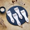 Lot de spatules à raclette en bois personnalisées avec gravure de prénoms et phrases humoristiques.