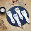 Lot de spatules à raclette en bois personnalisées avec gravure de prénoms et phrases humoristiques.