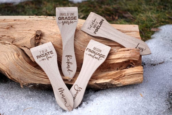 Lot de spatules à raclette en bois personnalisées avec gravure de prénoms et phrases humoristiques.