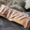 Lot de spatules à raclette en bois personnalisées avec gravure de prénoms et phrases humoristiques.