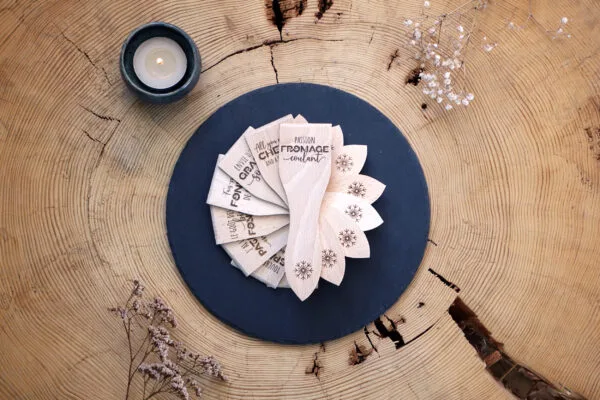Lot de spatules à raclette en bois personnalisées avec gravure de prénoms et phrases humoristiques.