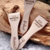 Lot de spatules à raclette en bois personnalisées avec gravure de prénoms et phrases humoristiques.