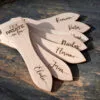 Lot de spatules à raclette en bois personnalisées avec gravure de prénoms et phrases humoristiques.